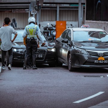 people looking at a car accident scene with police present